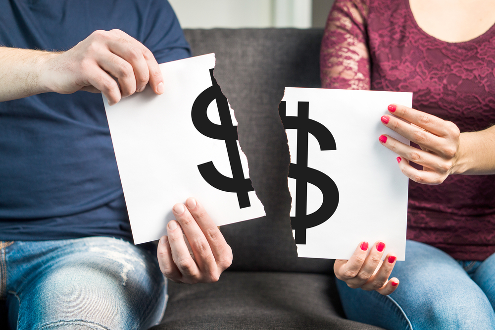man and woman holding ripped paper with dollar sign